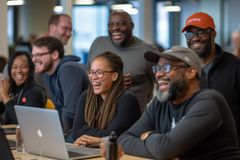Image of a diverse group of maintainers sitting at a table maintaining DDEV